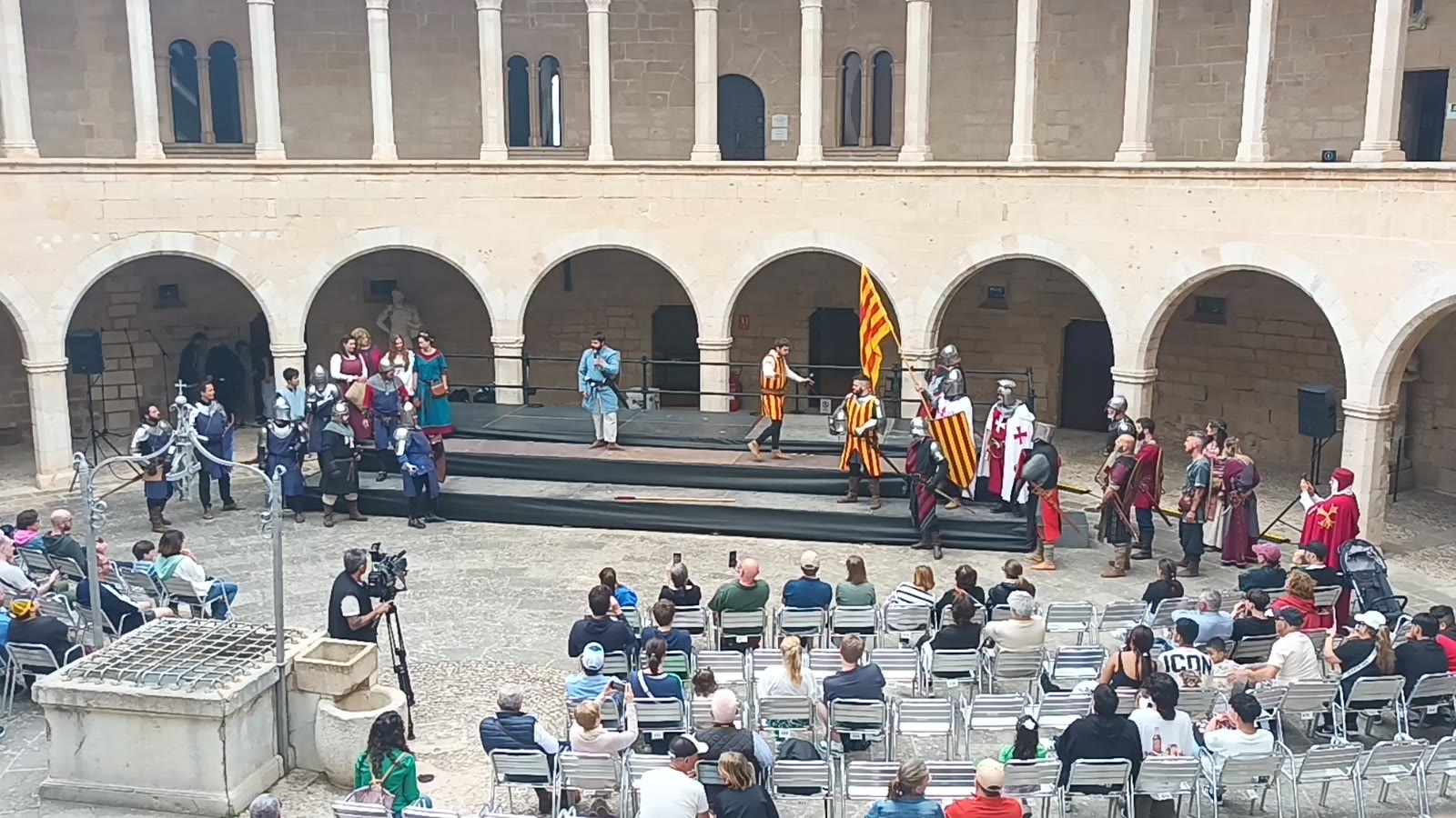 Representació teatral de Milites Maioricarum al pati del castell de Bellver, amb públic assegut.