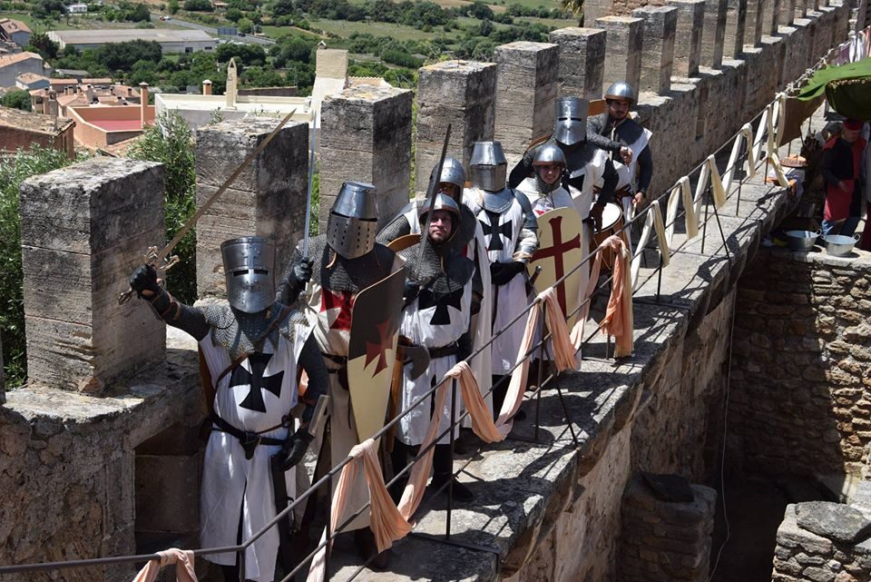 Fila de cavallers amb elms i escuts al camí de ronda de les murades del castell de Capdepera.